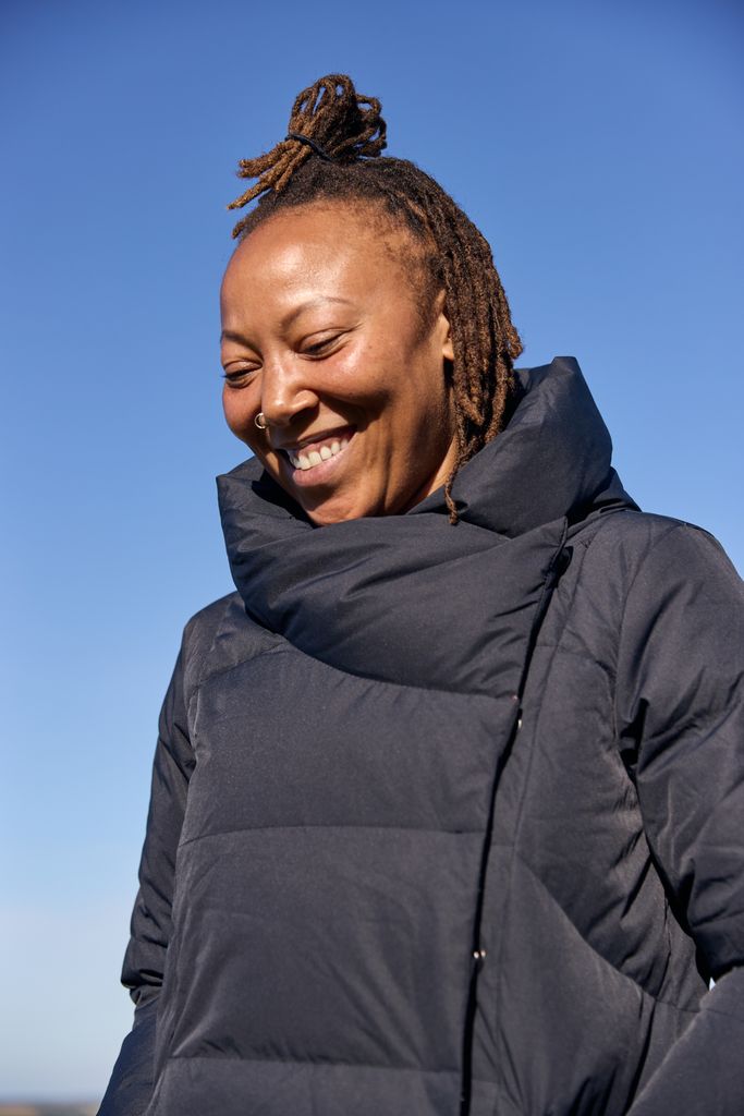 Black woman smiling in a puffer coat