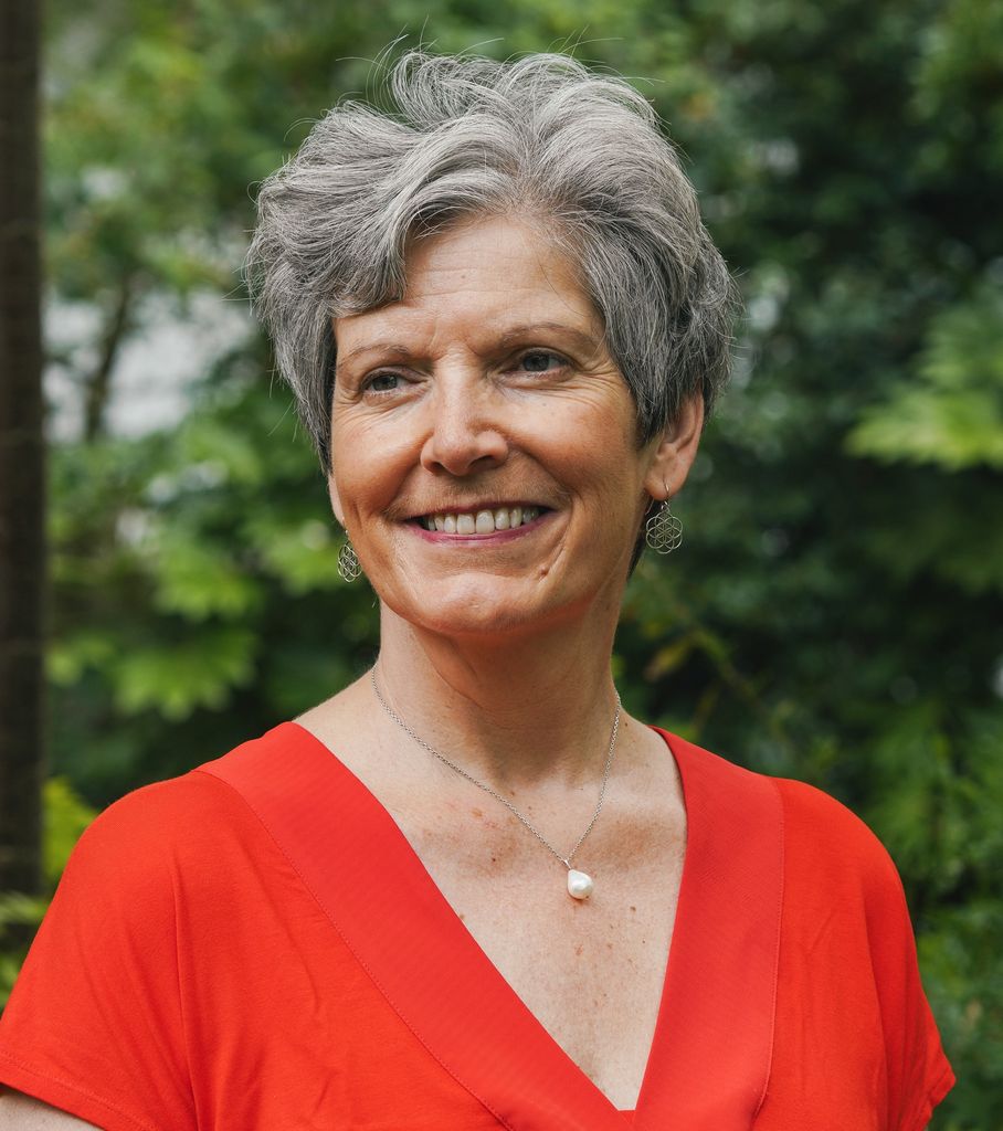 short grey haired women in a red top smiling 