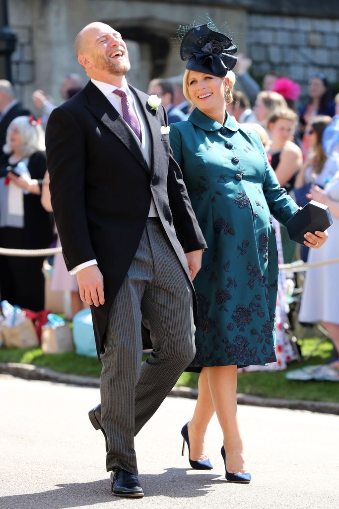 Mike Tindall laughing in a suit while Zara Tindall smiles and wearing a bump-skimming green coat dress at Harry and Meghan's wedding