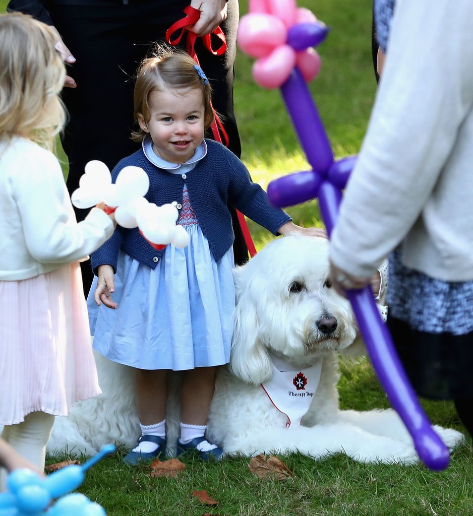 Princess Charlotte petting a dog named Moose during the Royal Tour of Canada