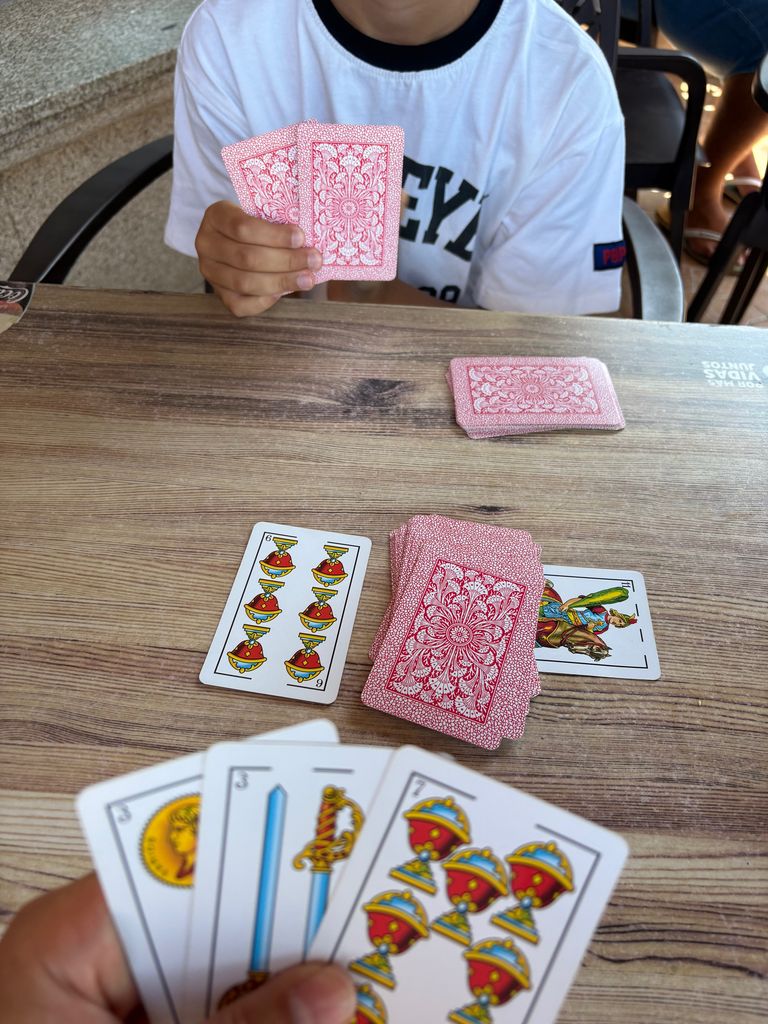 A mother and son playing Spanish card game
