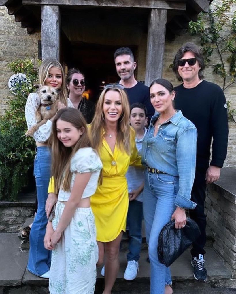 Amanda Holden and Simon Cowell posing for a photo alongside their families