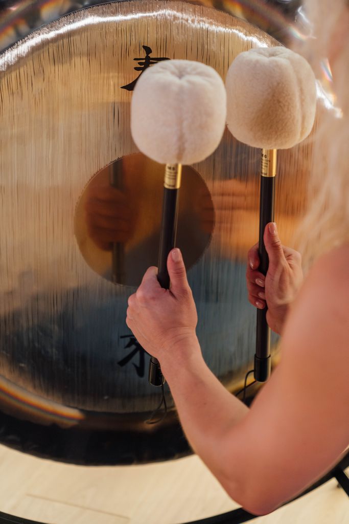 Hands playing a gong 
