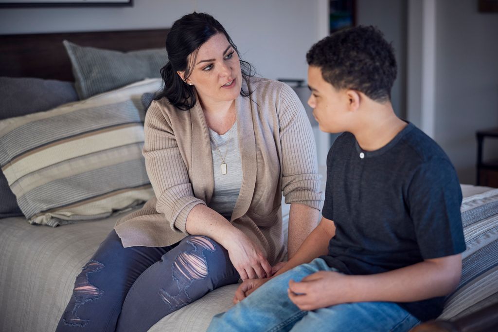 mother talking with son in bedroom.