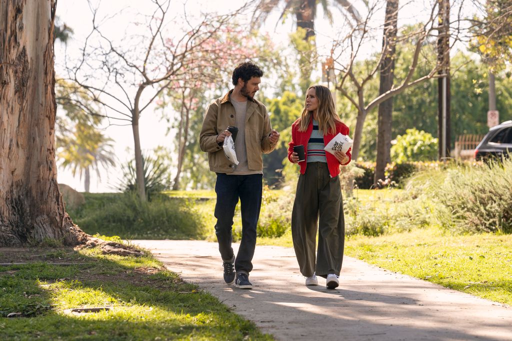 Kristen Bell wearing khaki trousers, striped top and red jacket on Nobody Wants This