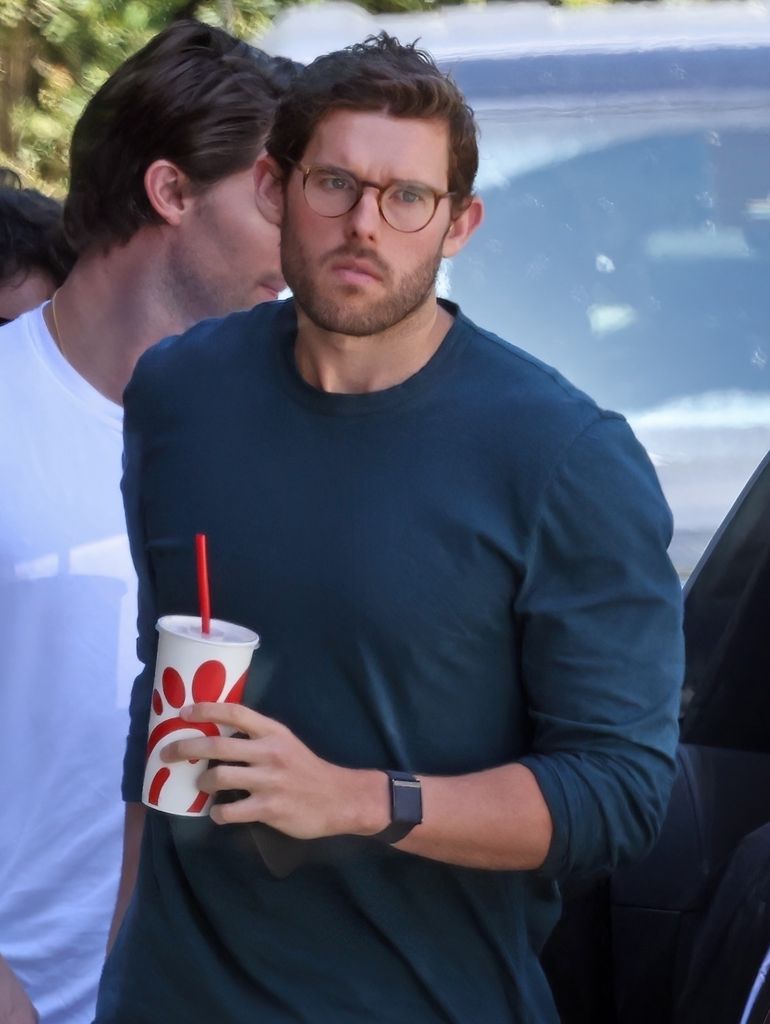 Christopher carrying drink wearing tight t shirt in shape 