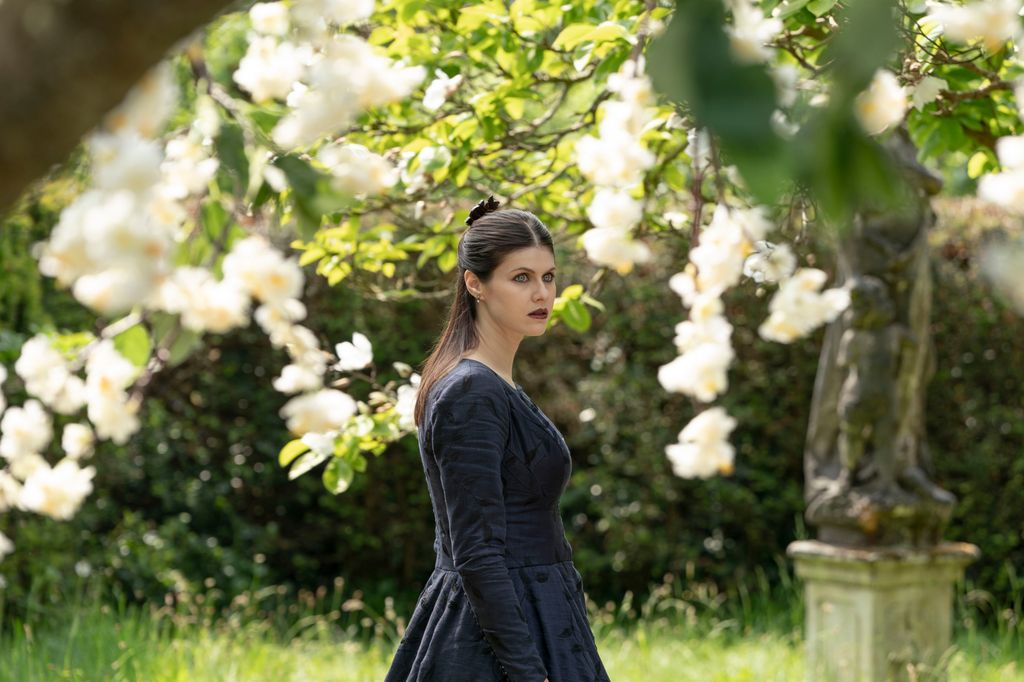 woman in dark dress standing in garden 