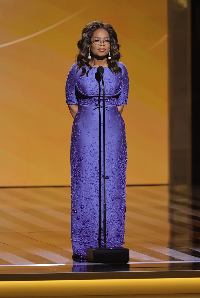Oprah em um vestido roxo no palco