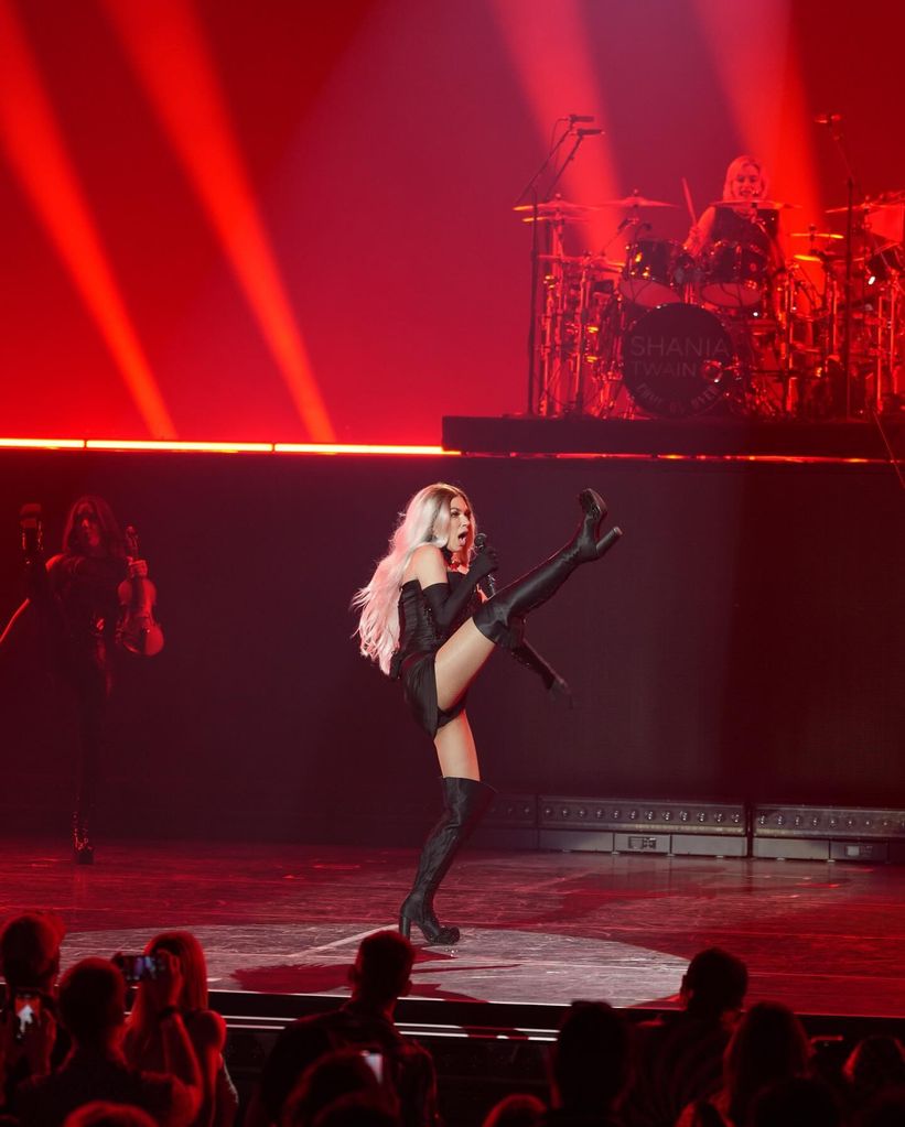 Shania Twain high kicking on stage