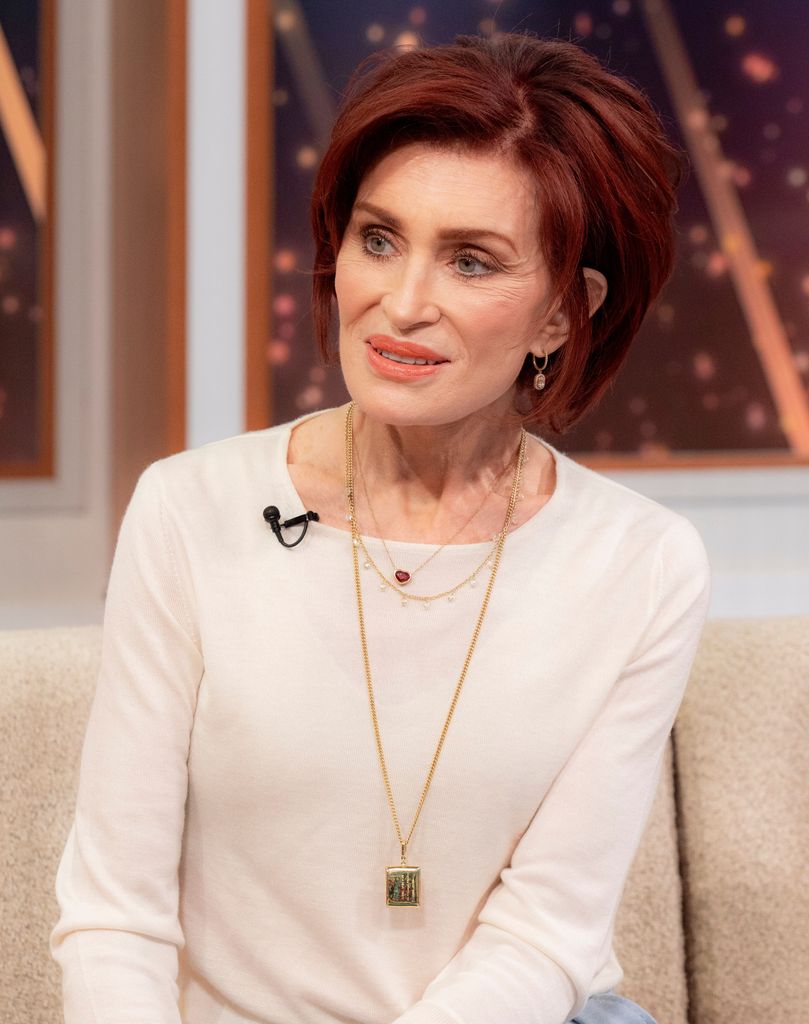 Sharon Osbourne in a white dress and gold necklace