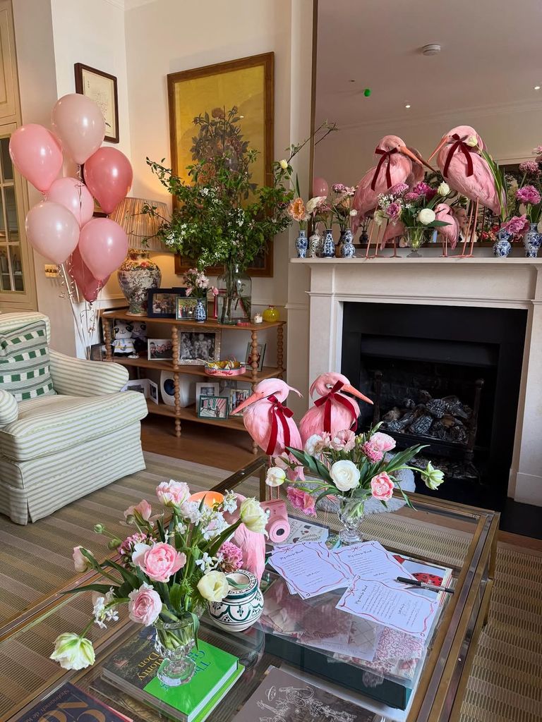 A beautifully styled baby shower setup featuring pink balloons, flamingo décor, floral arrangements, and personalized details — the perfect whimsical setting for Poppy Delevingne’s stylish celebration at home.