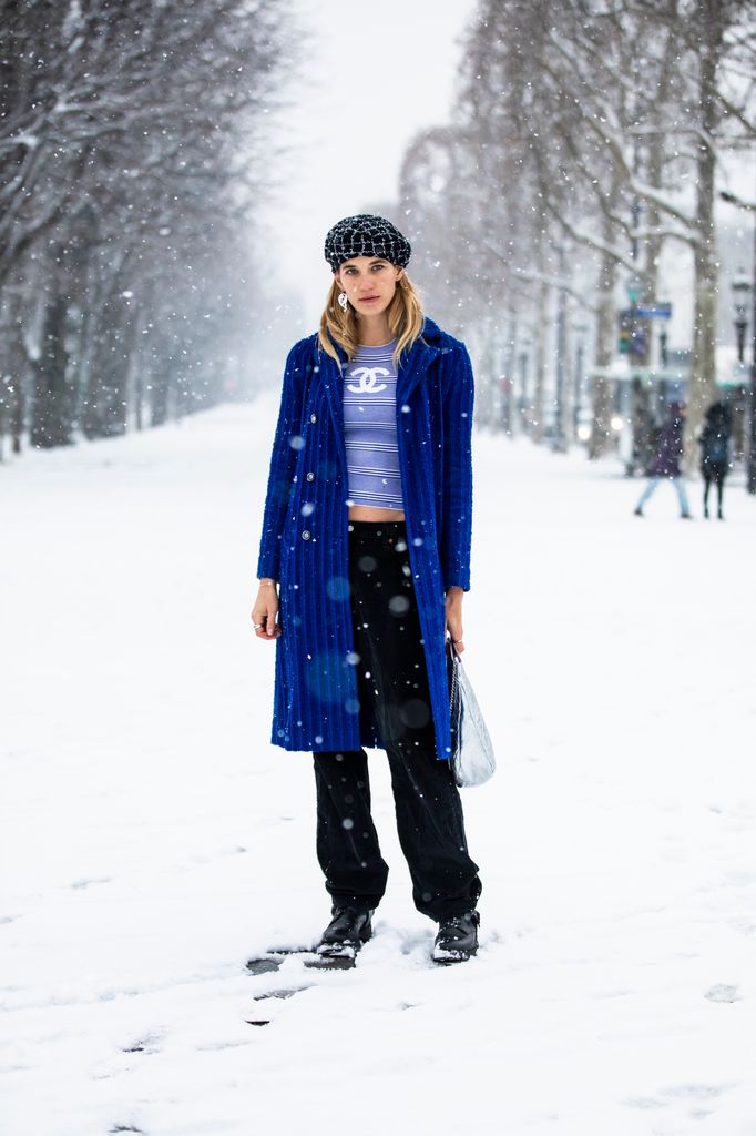 Veronika Heilbrunner  royal blue coat over a casual tee and black pants makes for a vibrant snow-day look. Paired with a trendy headpiece and minimal accessories, it’s a great way to add color to a snowy scene while keeping things casual and chic.