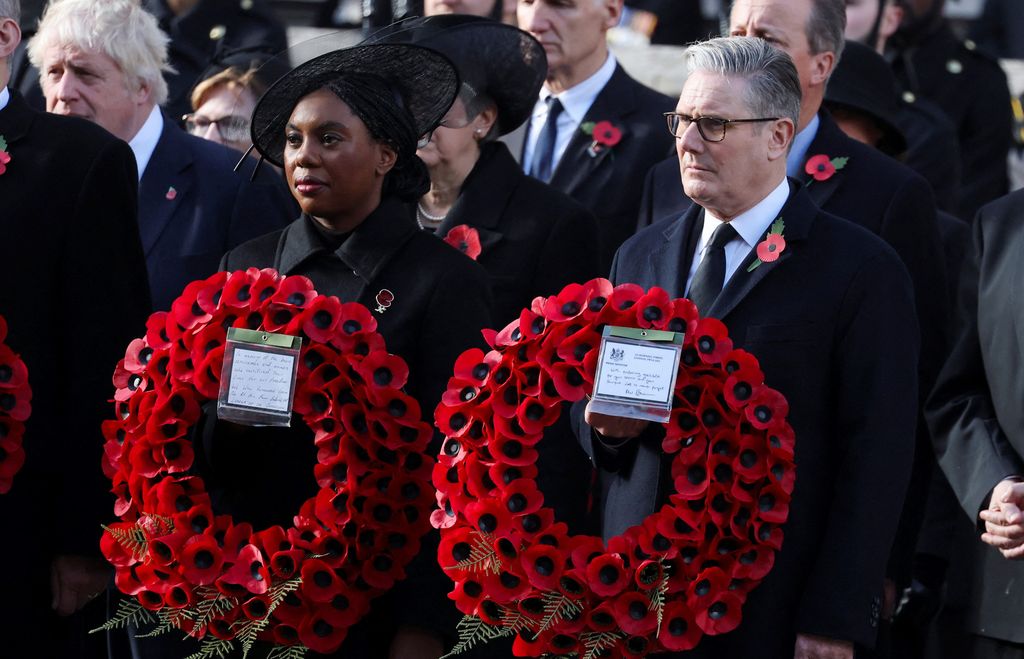 Prime Minister Keir Starmer and Britain's Conservative Party leader Kemi Badenoch carry wreaths during the the 2025 National Service Of Remembrance at The Cenotaph on November 9, 