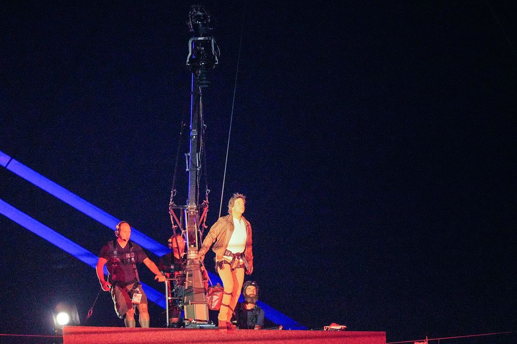 Tom Cruise is roped down in the stadium during the closing ceremony