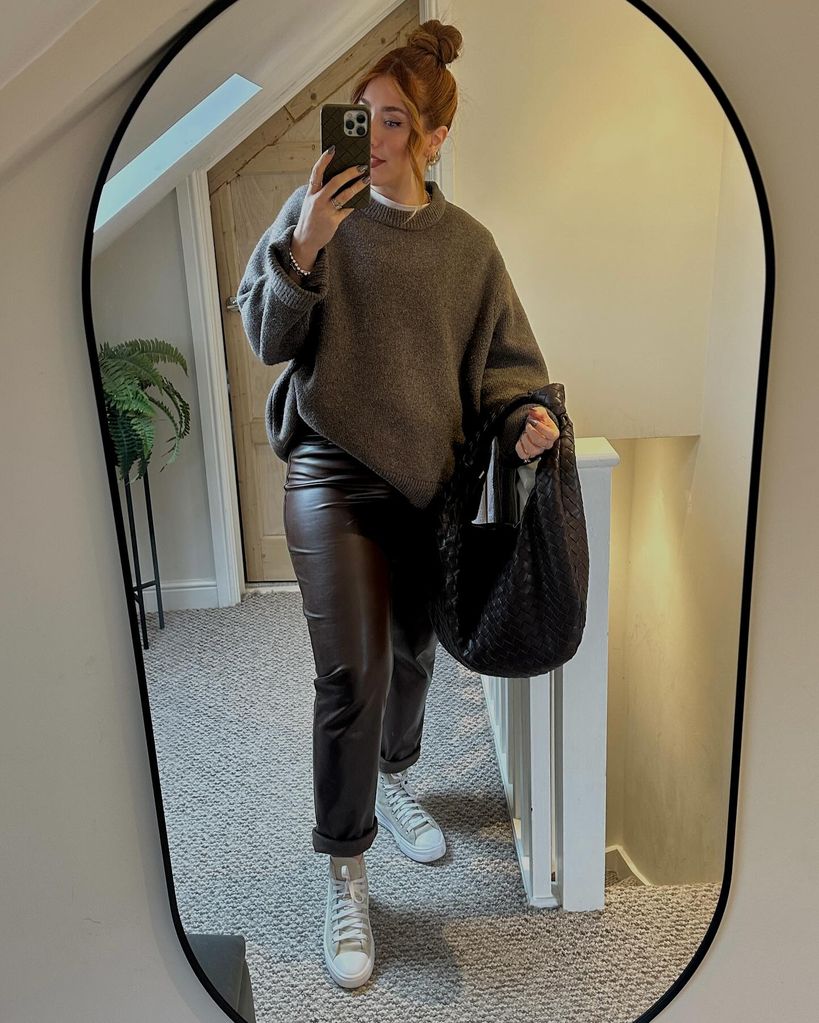 woman taking a mirror selfie in leather trousers 