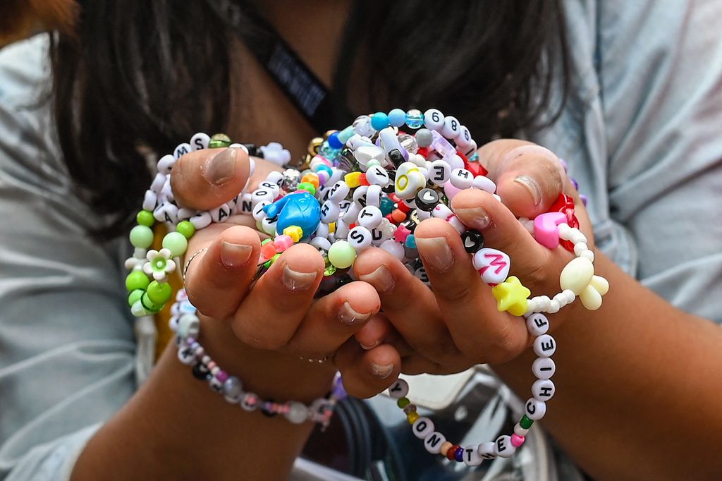 A fan of US singer Taylor Swift, also known as a Swiftie, holds friendship bracelets as she arrives for the first of the pop star's six sold-out Eras Tour concerts at the National Stadium in Singapore