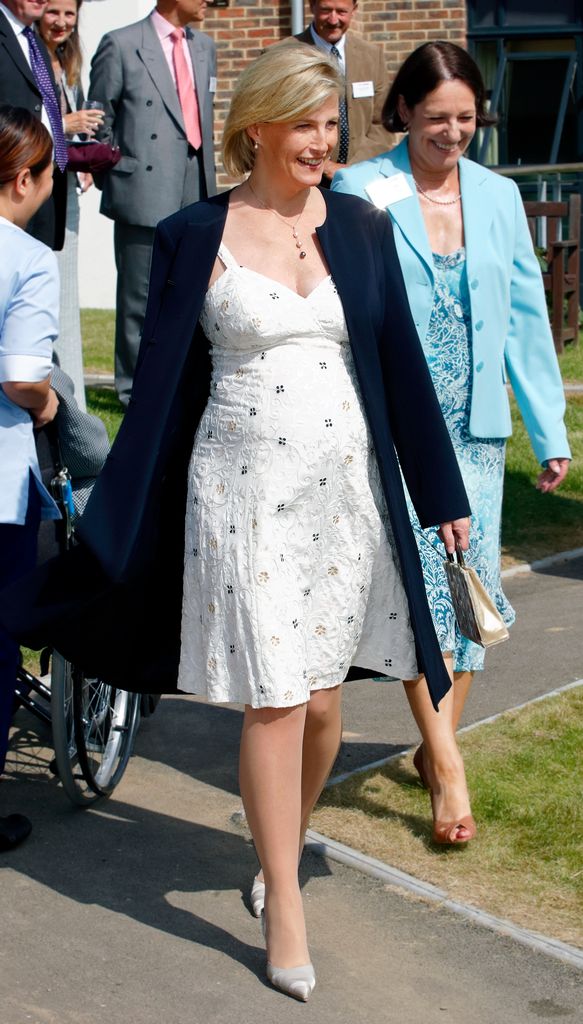 Sophie with baby bump in white sundress