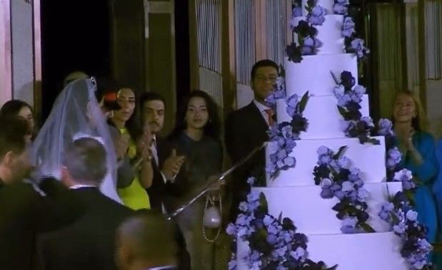 Princess Rajwa Al Saif of Jordan with royal wedding cake featuring seven tiers and blue flowers