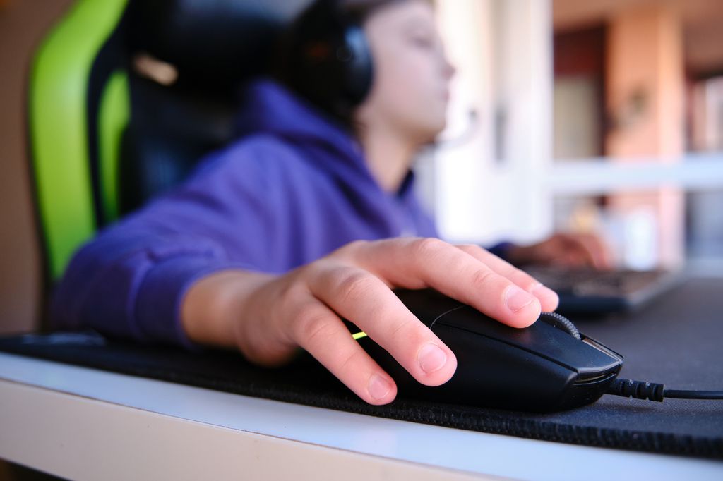 Close-up of a boy's hand with a gaming PC mouse gaming