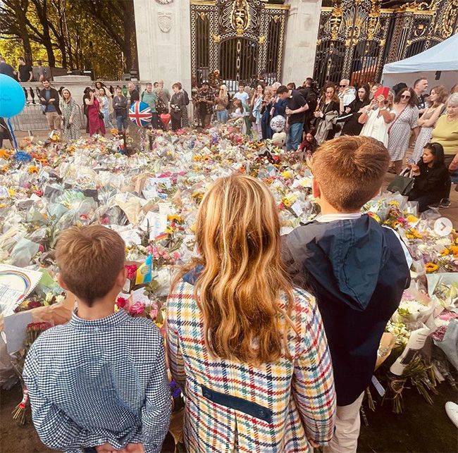 Three children stood in front of floral tributes