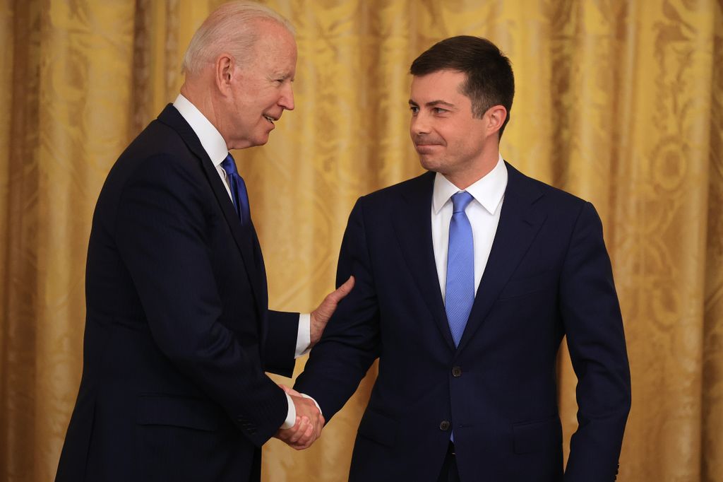 U.S. President Joe Biden (L) shakes hands with Transportation Secretary Pete Buttigieg in 2021