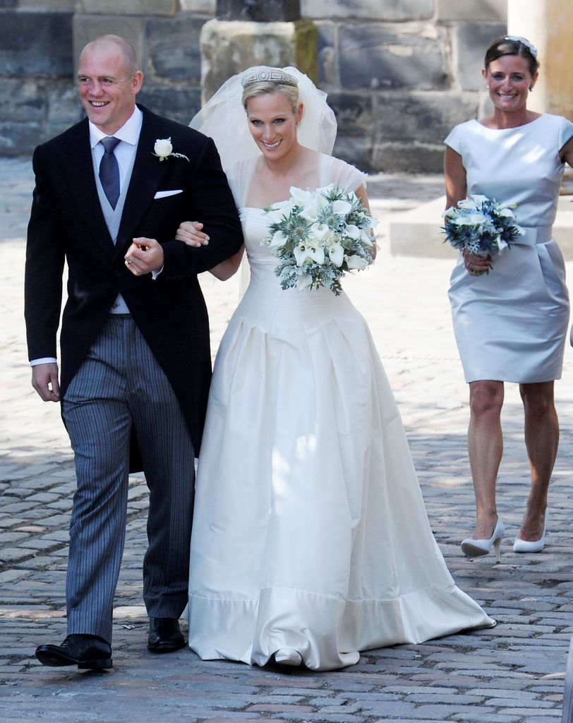 Zara Phillips and Mike Tindall smiling and linking arms on their wedding day