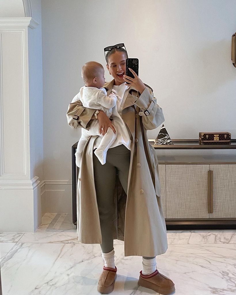 mother taking selfie while holding baby daughter