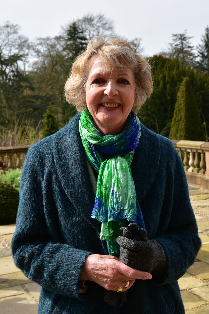 woman standing outside in teal coat 