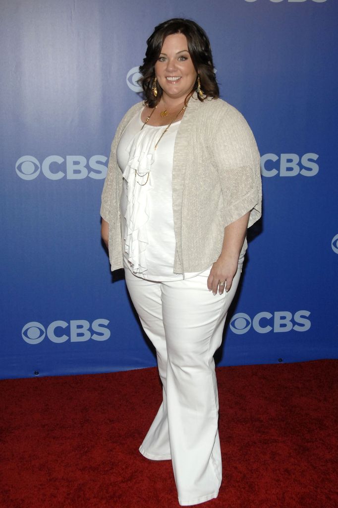 Melissa McCarthy wearing a white top and jeans smiling in 2010