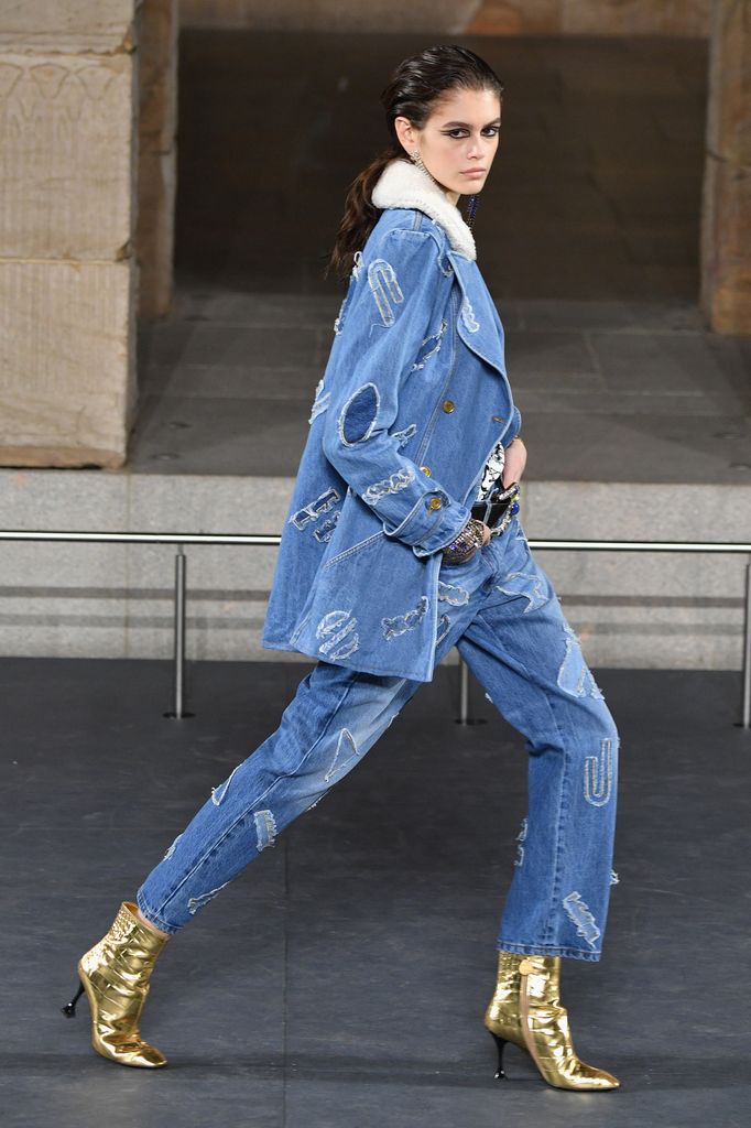 Kaia Gerber walks the runway at Chanel Metiers D'Art in mom jeans