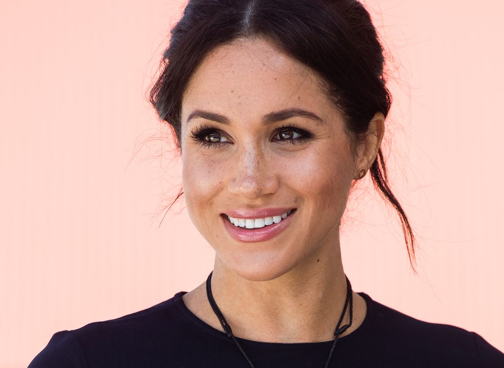 Meghan Markle smiling with her hair up