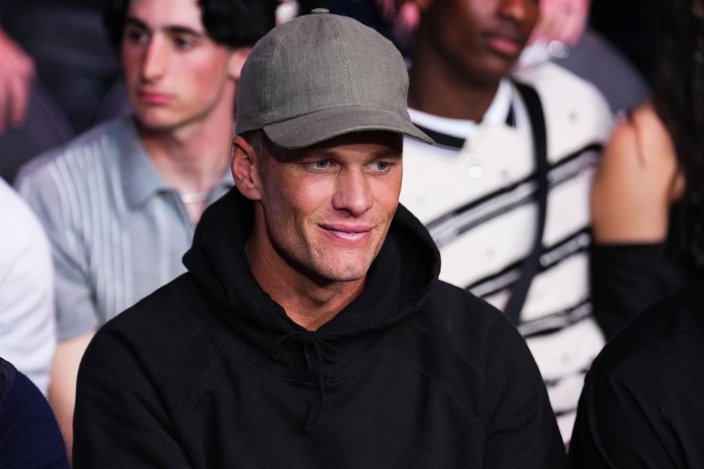 Tom Brady in black hoodie and cap