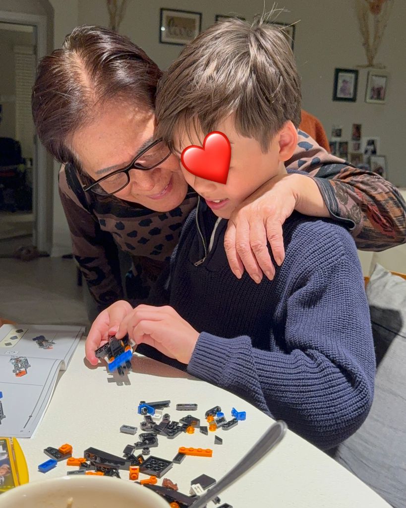 young boy making Lego structure with grandma