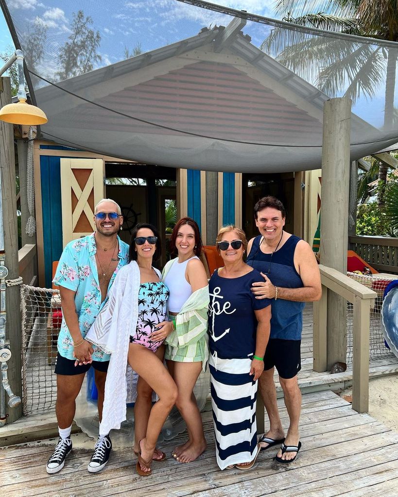 janette manrara in tropical print swimsuit posing with her family