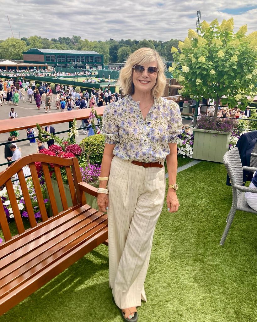 Glynis Barber in a floral shirt and striped trousers at Wimbledon 