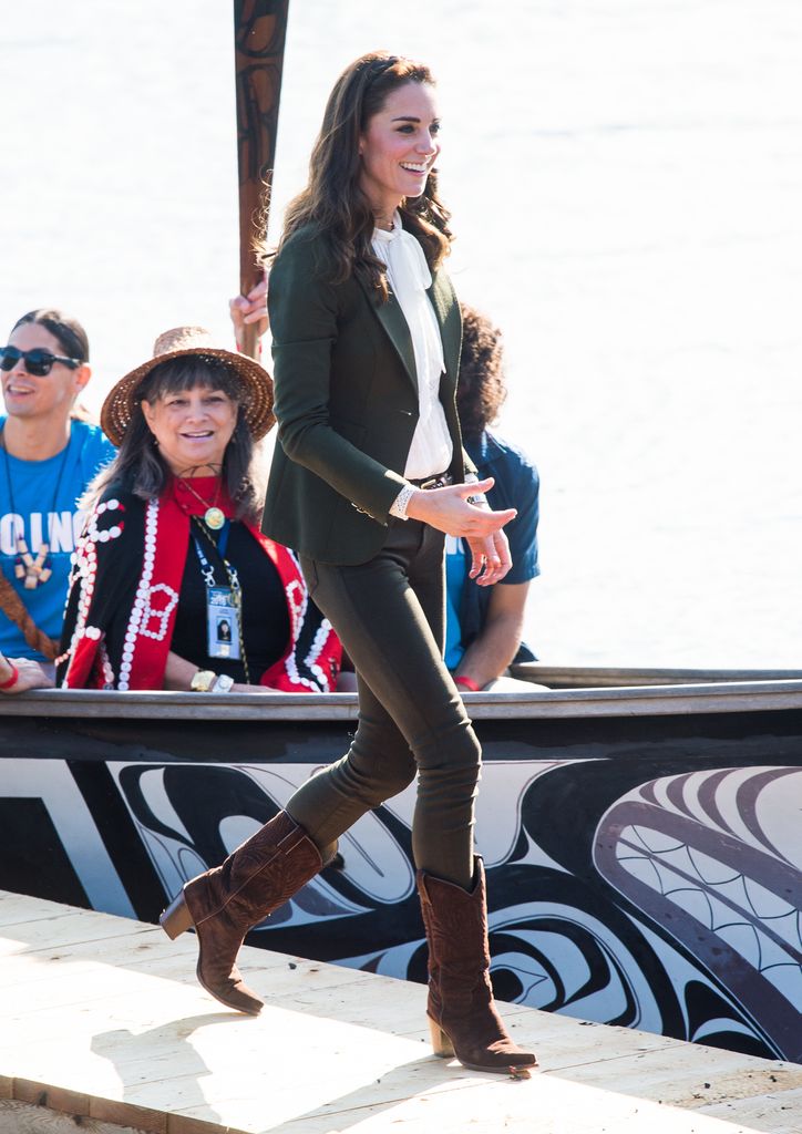 Kate arriving off boat in cowboy boots and khaki jeans