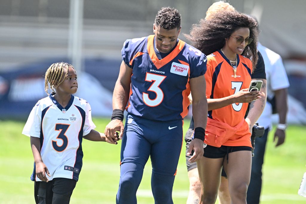 Russell with Ciara and their son Future on the football pitch before a game