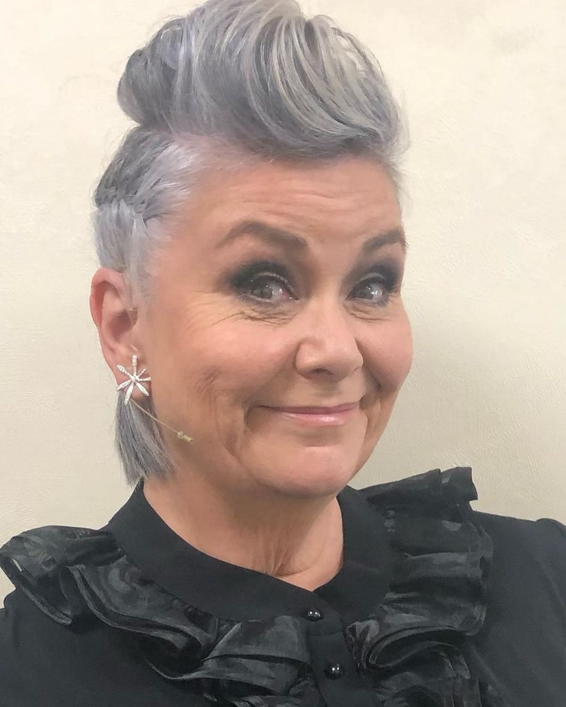 Dawn French with flower earrings and edgy grey hairdo