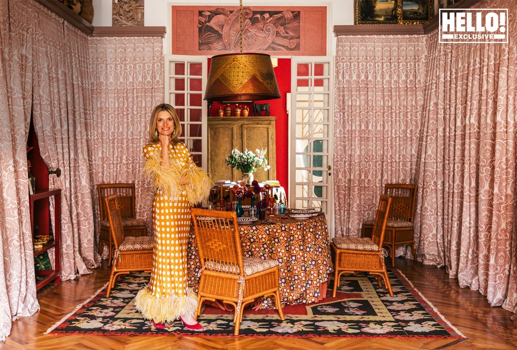 Martina Mondadori posing in eclectic dining room wearing yellow dress at home in Milan 