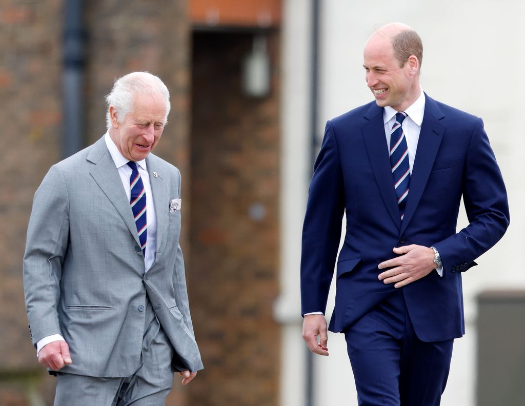 King Charles walking next to Prince William as both of them laugh