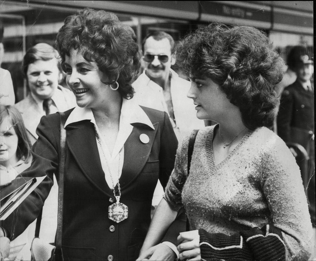 Black-and-white photo of Elizabeth Taylor walking with daughter Liza Todd