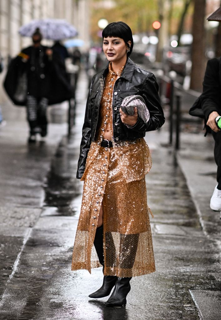 Maria Bernad is seen wearing a black jacket, Rabanne sheer sequined top and skirt with silver Rabanne bag outside the Rabanne show 