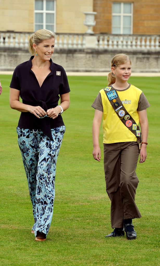 Duchess Sophie and Lady Louise Windsor walking through the grounds of Buckingham Palace with Lady Louise dressed as a Brownie