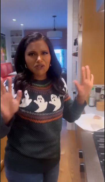 Mindy Kaling in a ghost jumper in the kitchen