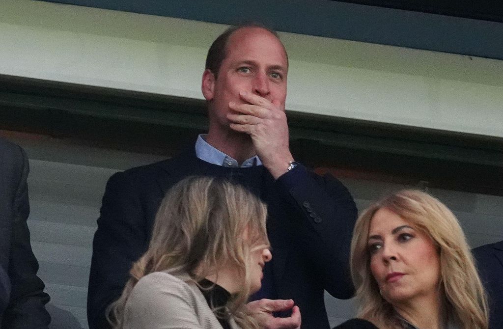 Prince William with his hand over his mouth