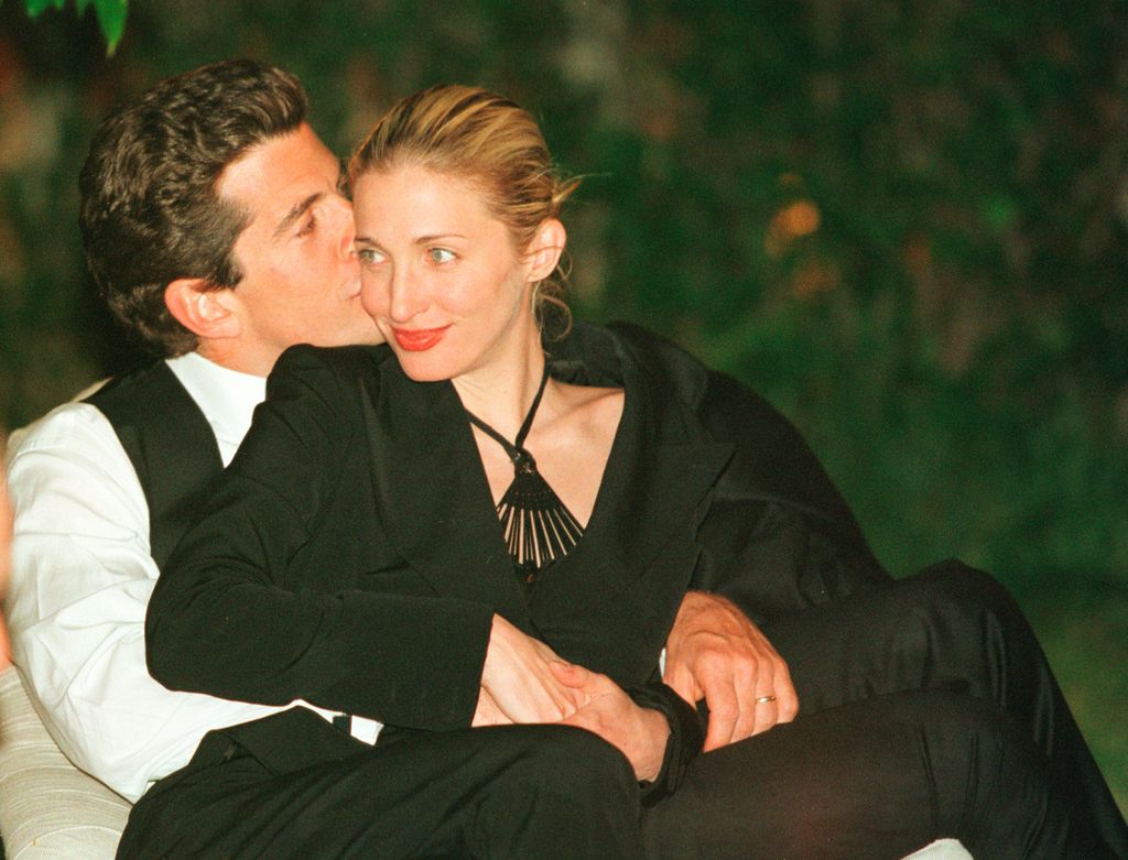 John F. Kennedy Jr., editor da revista George, dá um beijo na bochecha de sua esposa Carolyn durante o jantar anual dos correspondentes da Casa Branca em 1º de maio de 1999 em Washington, DC