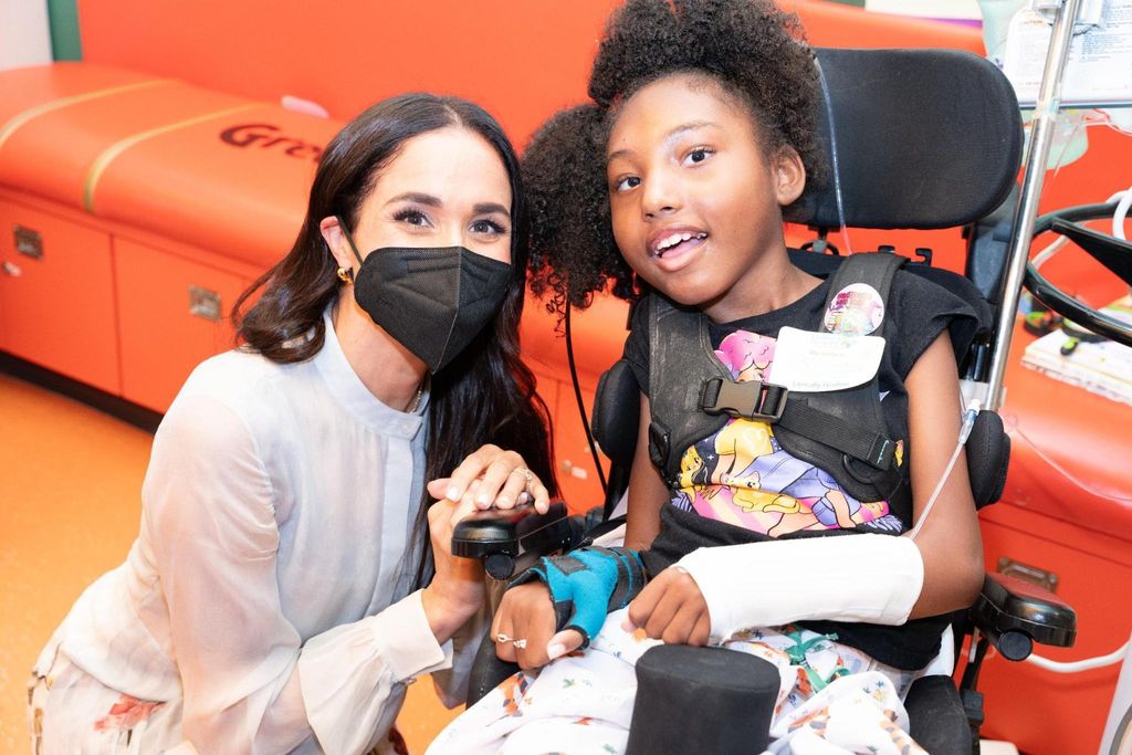 Meghan Markle poses for photograph with young patient at children's hospital