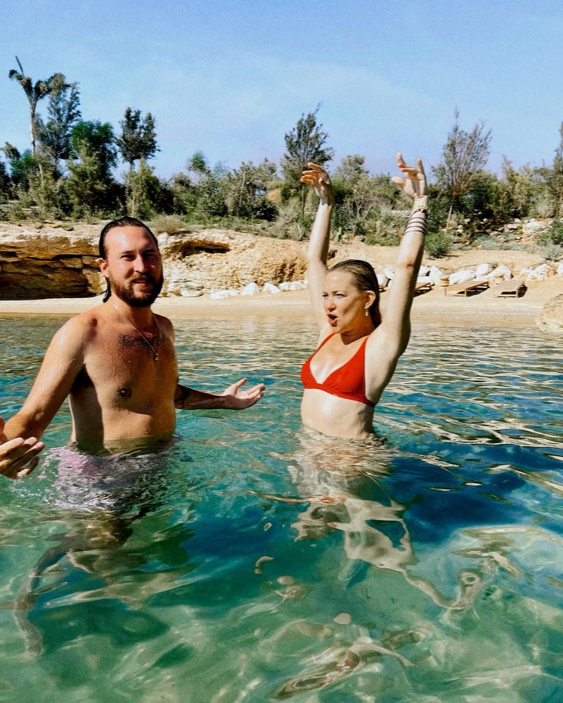 kate hudson and fiance danny fujikawa in the sea in greece