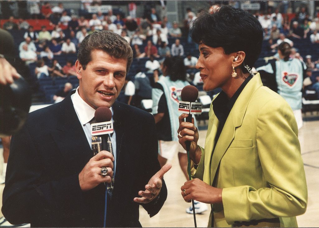 ESPN network commentator Robin Roberts (right) speaks with Italian-born American basketball coach Geno Auriemma of the University of Connecticut before an exhibition game between Connecticut and the New York Liberty, Storrs, Connecticut, 1998
