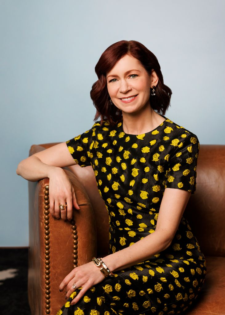 Carrie Preston poses on a leather sofa